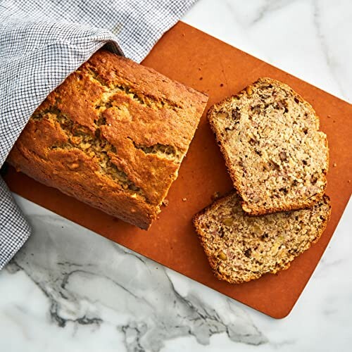 Banana bread loaf with two slices on a cutting board