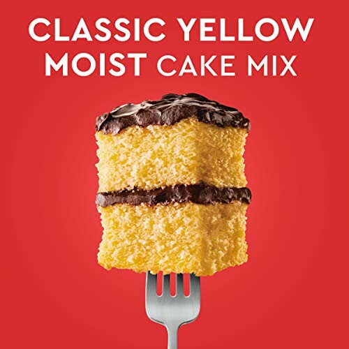 Slice of yellow cake with chocolate frosting on a fork, red background.