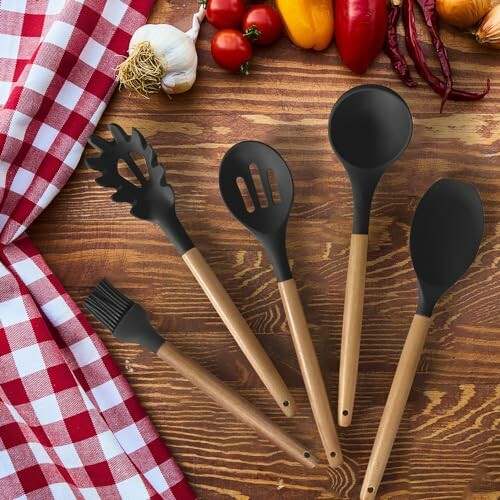 Assorted kitchen utensils on a wooden table with vegetables.